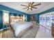 Spacious main bedroom with blue walls, stylish lighting, built-in bookcase, and outdoor access at 4216 Bur St, Port Charlotte, FL 33948
