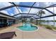 Screened-in pool area with water view, outdoor dining set, and lounge chairs at 4216 Bur St, Port Charlotte, FL 33948
