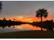 Stunning water view at sunset with palm tree silhouettes, creating a tranquil and scenic backdrop at 4216 Bur St, Port Charlotte, FL 33948