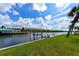 Backyard view of waterfront property featuring a private boat lift and lush grass along the canal's edge at 4216 Bur St, Port Charlotte, FL 33948