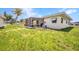 Green backyard with a screened-in patio and awning-covered window, promising outdoor relaxation and comfort at 426 Burland St, Punta Gorda, FL 33950