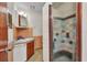 Functional bathroom featuring tiled walls, vanity sink, and a shower with a patterned glass door at 426 Burland St, Punta Gorda, FL 33950