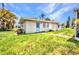 Charming single-story home with a grassy yard and a light blue front door under a sunny, partly cloudy sky at 426 Burland St, Punta Gorda, FL 33950