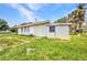 View of a single-story home showing the back exterior with a small table and grassy yard at 426 Burland St, Punta Gorda, FL 33950