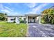Front exterior of home featuring a carport, tropical plants, and a blue door at 426 Burland St, Punta Gorda, FL 33950