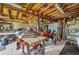 The messy garage features exposed yellow painted beams and is filled with furniture and tools at 426 Burland St, Punta Gorda, FL 33950