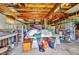 The cluttered garage has exposed rafters and is filled with tools, furniture, and household items at 426 Burland St, Punta Gorda, FL 33950