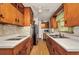 Traditional kitchen with wooden cabinets, neutral countertops, and a ceiling fan at 426 Burland St, Punta Gorda, FL 33950