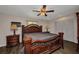 This main bedroom boasts an ornamental wood bed frame, ceiling fan, and double-door closets at 426 Burland St, Punta Gorda, FL 33950