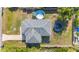 An aerial view of a home with a lush backyard featuring a pool, trampoline, and a spacious driveway at 4702 Westwood Dr, Punta Gorda, FL 33982