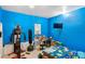 The bedroom features bright blue walls, a desk, a bed and exercise equipment at 4702 Westwood Dr, Punta Gorda, FL 33982