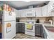 Well-lit kitchen with white cabinets, stainless steel sink, grey lower cabinets, and wood-look flooring at 4702 Westwood Dr, Punta Gorda, FL 33982