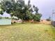 Large backyard with green grass, mature trees, a storage shed, and a wood privacy fence at 481 Reading Nw St, Port Charlotte, FL 33952