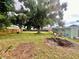 Spacious backyard featuring mature trees, green grass, a fire pit, and fencing at 481 Reading Nw St, Port Charlotte, FL 33952