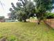 Expansive backyard featuring healthy grass, mature trees providing shade, and a wood fence for privacy at 481 Reading Nw St, Port Charlotte, FL 33952