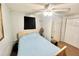 Modest bedroom with ceiling fan, simple decor, and a view of a door and mirror at 481 Reading Nw St, Port Charlotte, FL 33952