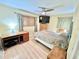 Bedroom with wood flooring, ceiling fan, a desk, and a cozy bed with neutral bedding at 481 Reading Nw St, Port Charlotte, FL 33952