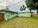 Exterior view of a home with green siding, showcasing the backyard and air conditioning unit at 481 Reading Nw St, Port Charlotte, FL 33952