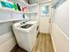 Bright laundry room with a modern white washing machine and dryer, shelves and a window at 481 Reading Nw St, Port Charlotte, FL 33952