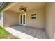 Covered back porch with tiled floors, ceiling fan, and a view of the lush yard at 4862 Kiska Rd, North Port, FL 34288