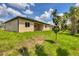 A beautifully landscaped backyard featuring a well-maintained lawn, young trees, and a covered patio at 4862 Kiska Rd, North Port, FL 34288
