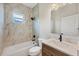 Modern bathroom featuring marble tiles, a bathtub, and a sleek vanity with updated fixtures at 4862 Kiska Rd, North Port, FL 34288