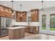 Modern kitchen featuring wood cabinets, stainless steel appliances, pendant lighting, and an island at 4862 Kiska Rd, North Port, FL 34288
