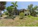 Large backyard featuring a screened lanai, mature trees, and a meticulously manicured lawn at 5023 Key Largo Dr, Punta Gorda, FL 33950