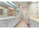 A spacious bathroom boasts dual sinks, white cabinets, and unique seashell wallpaper at 5023 Key Largo Dr, Punta Gorda, FL 33950