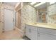 This bathroom offers a shower, sink with storage, and seashell wallpaper at 5023 Key Largo Dr, Punta Gorda, FL 33950