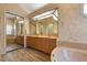 Well-appointed bathroom boasting wood-look tile floors, double sinks, and a mirrored closet for ample storage at 5023 Key Largo Dr, Punta Gorda, FL 33950