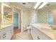 Bathroom featuring dual sinks, neutral countertops, tile floors, and seashell wallpaper at 5023 Key Largo Dr, Punta Gorda, FL 33950