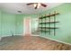This bedroom features a fan, light green walls, wood-look floors, and built in shelves at 5023 Key Largo Dr, Punta Gorda, FL 33950