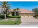 Charming single-story home with a brick driveway, three-car garage, and lush landscaping at 5023 Key Largo Dr, Punta Gorda, FL 33950