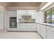 Bright kitchen features white cabinetry, tile backsplash, and stainless steel oven appliance at 5023 Key Largo Dr, Punta Gorda, FL 33950