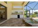 Outdoor kitchen with white cabinets, sink, mini refrigerator and tile backsplash at 5023 Key Largo Dr, Punta Gorda, FL 33950