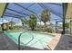 Screened-in pool with patio area surrounded by tropical landscaping and waterfront views at 5023 Key Largo Dr, Punta Gorda, FL 33950