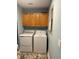 Bright laundry room with washer, dryer, and upper cabinets at 5114 Melbourne St # A302, Punta Gorda, FL 33980