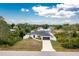 Charming single-story home surrounded by lush trees, well-kept lawn, and black roof and garage doors at 5532 Veracruz Ter, Port Charlotte, FL 33981