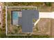 Aerial view of a residence featuring a screened-in pool, set within its property lines and adjacent landscaping at 5532 Veracruz Ter, Port Charlotte, FL 33981