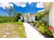A landscaped front yard with a stone walkway leading up to the home's entrance on a sunny day at 5532 Veracruz Ter, Port Charlotte, FL 33981
