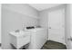 A dedicated laundry room features a utility sink, shelving, and modern appliances at 5532 Veracruz Ter, Port Charlotte, FL 33981