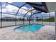 Beautiful screened-in pool area with a curved design, and spacious stone patio at 5532 Veracruz Ter, Port Charlotte, FL 33981