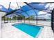 Sunlit screened-in pool with ladder steps, surrounding stone patio, and an enclosed fence around the home at 5532 Veracruz Ter, Port Charlotte, FL 33981