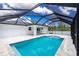 Screened-in pool with stone steps leading into clear water with access to lanai and surrounding vegetation at 5532 Veracruz Ter, Port Charlotte, FL 33981