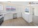 Updated kitchen with modern appliances, white cabinetry, quartz countertops and eat-in counter at 6850 S Biscayne Dr, North Port, FL 34287