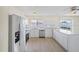 Updated kitchen with stainless steel appliances, white cabinets, and a breakfast bar at 6850 S Biscayne Dr, North Port, FL 34287