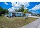 Charming single-story home with a blue exterior, well-kept lawn and white trim around the windows at 7231 Elyton Dr, North Port, FL 34287