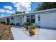 Well manicured front yard and landscape with a blue one story home at 7231 Elyton Dr, North Port, FL 34287