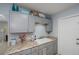 Galley kitchen featuring neutral cabinets, granite countertops, stainless steel appliances, and a sink at 7231 Elyton Dr, North Port, FL 34287